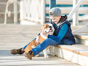 Junge sitzt mit dem Hund auf der Treppe